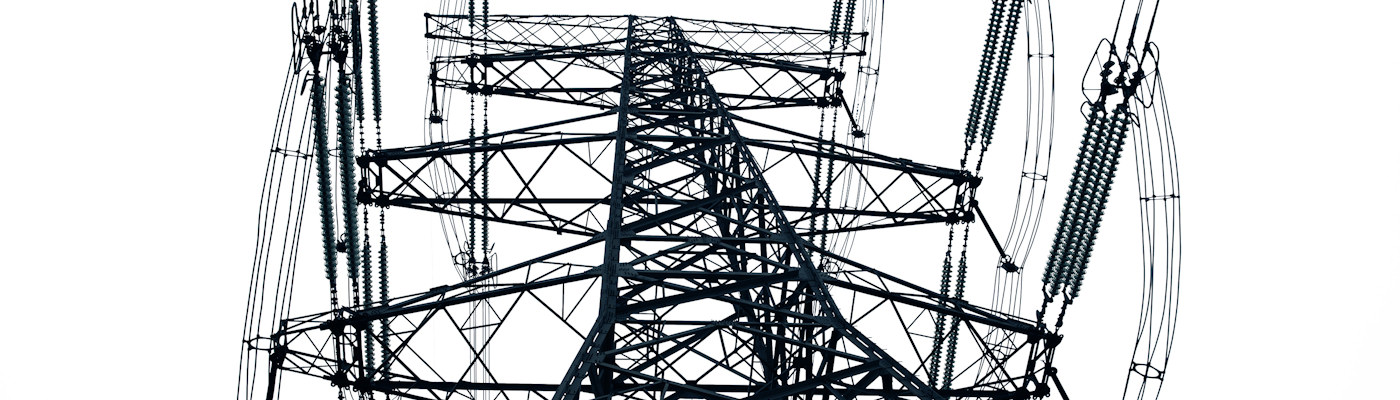 Ground view of electricity pylon in front of overcast sky