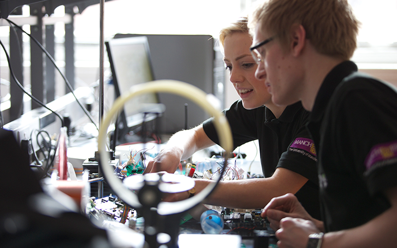 Two students working on robotics project in workshop